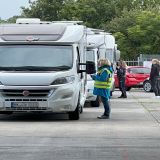 Eine Schlange von Wohnmobilen. Polizeibeamte stehen neben den Fahrerfenstern.